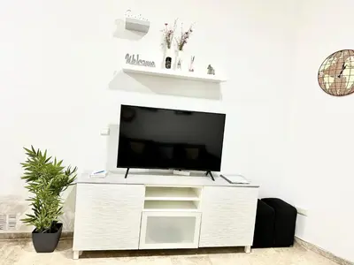 Una televisión o centro de entretenimiento en Apartamento acogedor y moderno en pleno centro de Sevilla con Parking Gratis