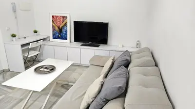 Una televisión o centro de entretenimiento en Wish Suite Feria de Sevilla