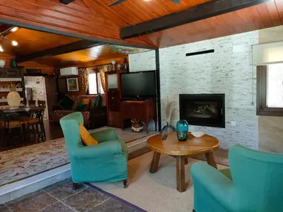 Una televisión o centro de entretenimiento en CABAÑA DE MADERA JUNTO AL LAGO LAS JARAS