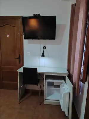 Una televisión o centro de entretenimiento en Pensión y apartamentos El Taxi