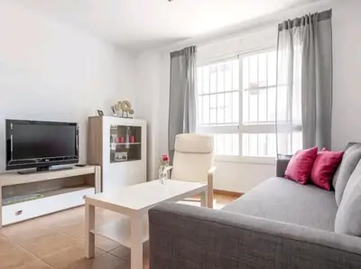 Una televisión o centro de entretenimiento en Apartamento con patio y piscina cerca de Sevilla